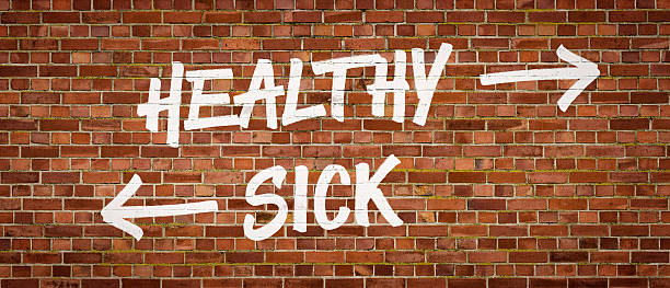 istock Healthy or Sick written on a brick wall 518273008