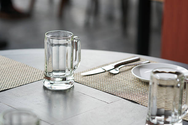 istock empty glass mug, cutlery and white dish 518273502
