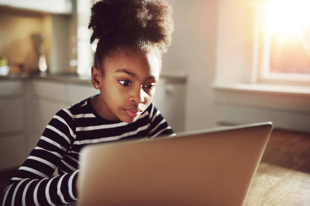 czarny nastolatek dziewczyna oglądając film na laptopie poważne - wireless technology serious education enjoyment zdjęcia i obrazy z banku zdjęć