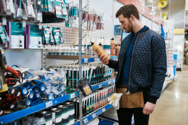 Young handyman or DIY homeowner in a store Young handyman or DIY homeowner in a store standing selecting a product in the hardware department and reading the label hardware store stock pictures, royalty-free photos & images