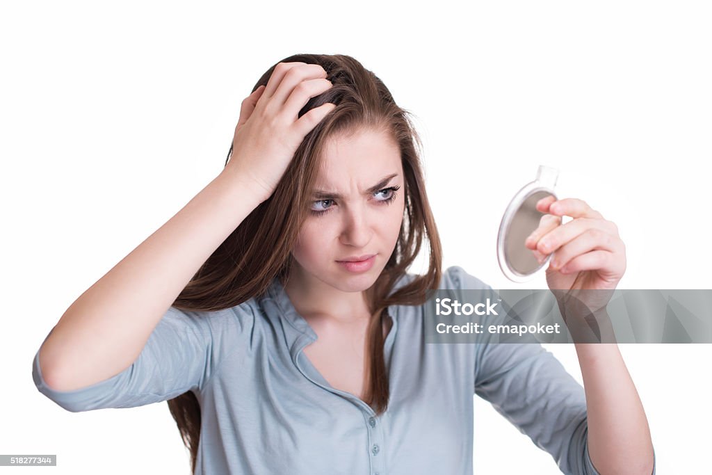 Woman looking at the first grey hair on her scalp Gray Hair Stock Photo