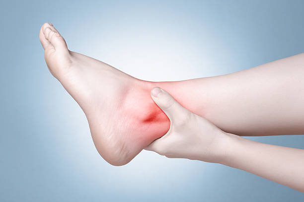 Female foot with ankle pain A young woman massaging her painful ankle ankle stock pictures, royalty-free photos & images