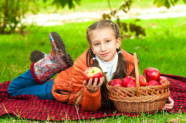 istock Little girl with apples in  park 518278833