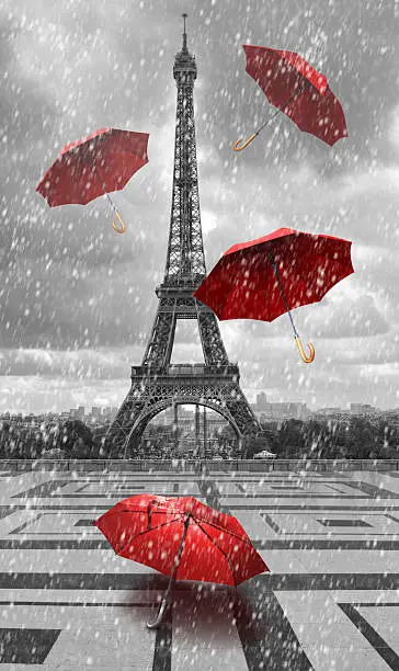 Photo of Eiffel tower with flying umbrellas.