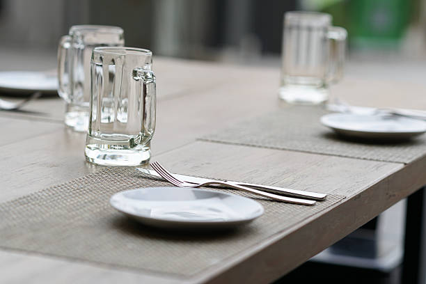istock empty glass mug, cutlery and white dish 518279996