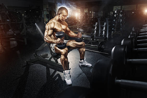 istock Athlete in the gym training with dumbbells 518280767