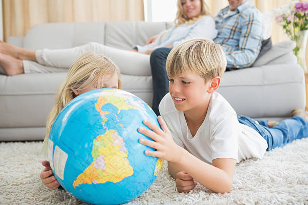 istock Siblings looking at globe on the floor 518281759
