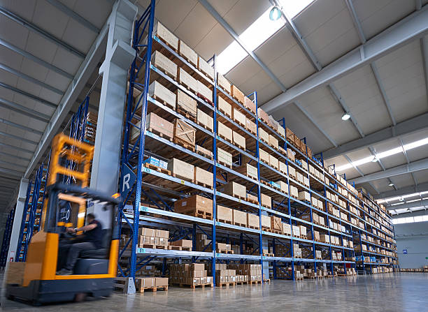istock Forklift carrying cardboard box in warehouse. Low angle view 518282082