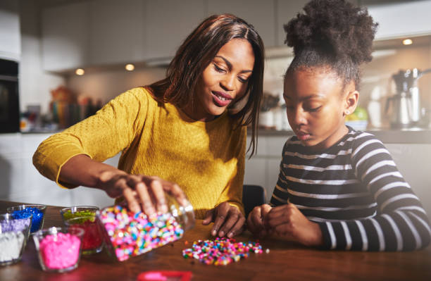 istock Adult pouring beads on table for child 518283078