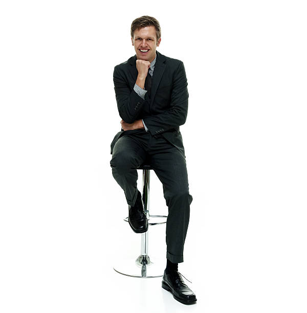 istock Smiling businessman sitting on stool 518285620