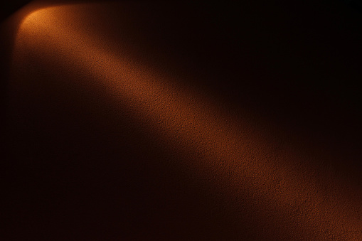 Lamp and ray of light on a wall in the darkness. This image can be used either as concept of intuition, insight, memory, understanding, etc. or as copy space