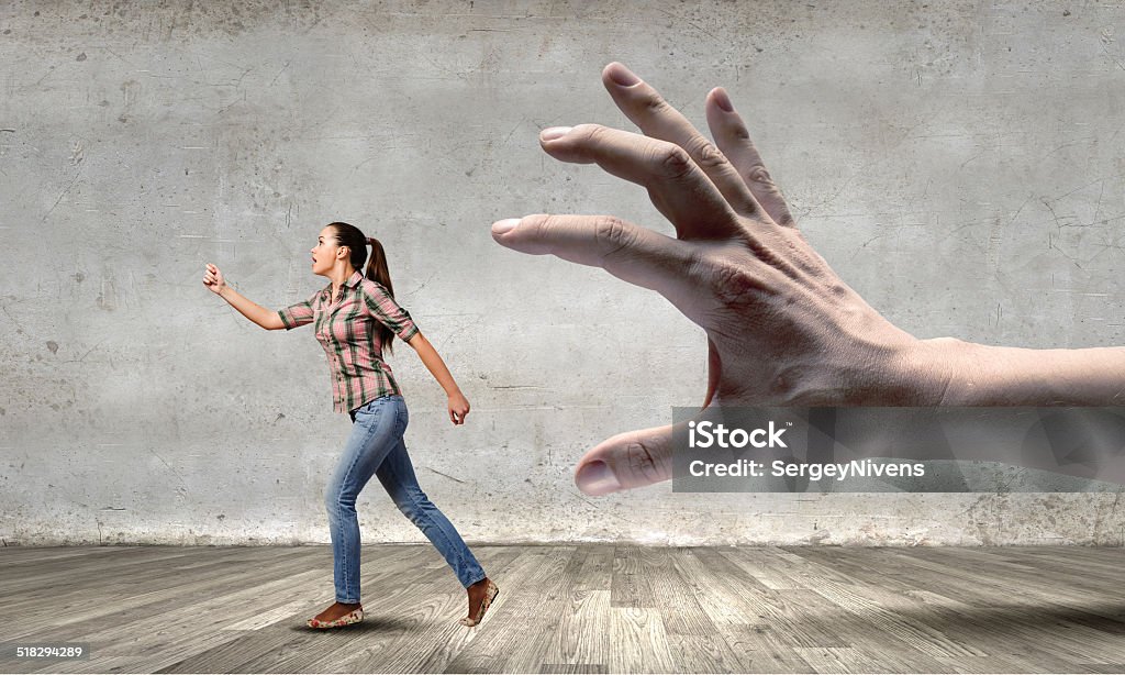 Woman escape from hand Young woman in casual running away from big hand Adult Stock Photo