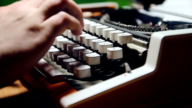 Male human hands write with an old fashion typewriter machine