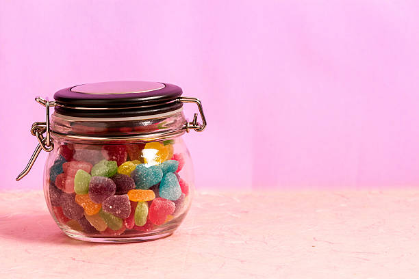 istock Colorful candy in bottle pink background 518306396