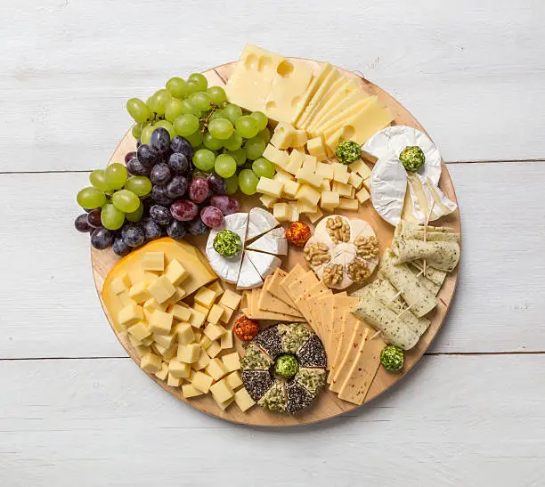 Cheese plate variation on a wooden white table.