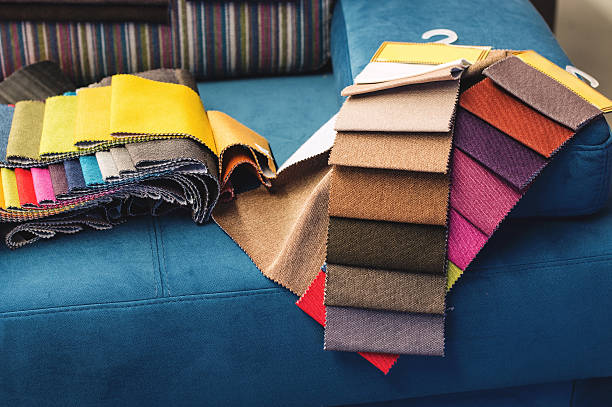 Colorful upholstery fabric samples Upholstery fabric samples in different colours on a blue sofa in a furniture store. upholstered furniture stock pictures, royalty-free photos & images