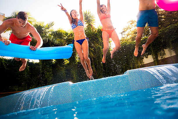 istock Friends Jumping in Swimming Pool 518307021