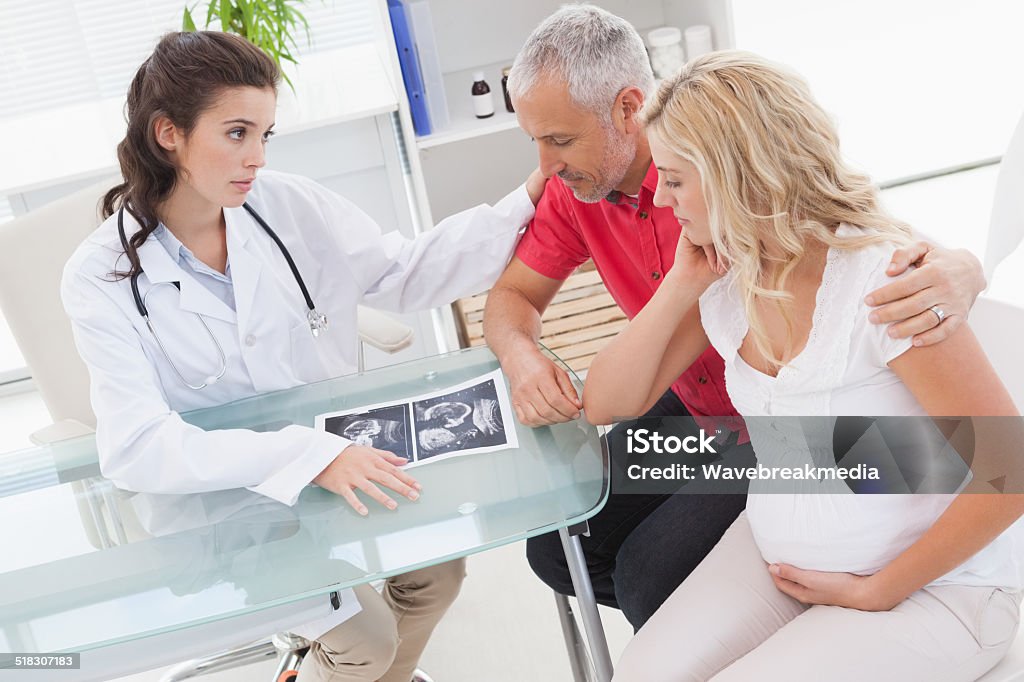 Doctor and nervous patient examining ultrasound Doctor and nervous patient examining ultrasound in medical office Anxiety Stock Photo