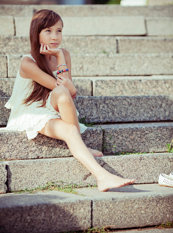 Little girl sitting on the stairs outdoors