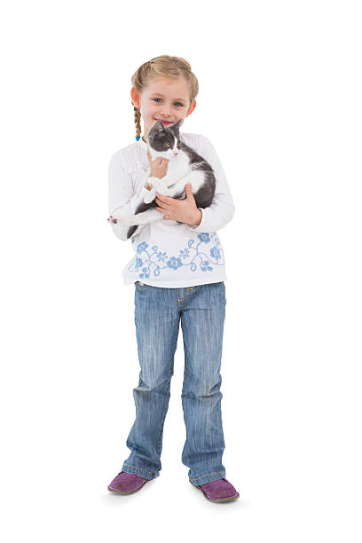 Happy four year old girl and kitten looking at each other. Isolated on white.