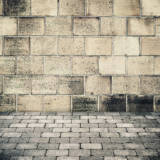 istock Old stone wall and gray cobblestone pavement 518308278