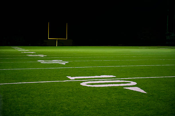 yard chiffres et de ligne sur terrain de football américain en soirée - thirty yard line photos et images de collection