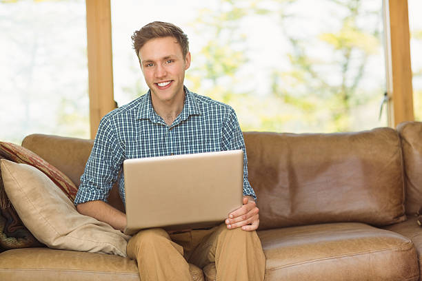 istock Young man relaxing on his couch with laptop 518309797