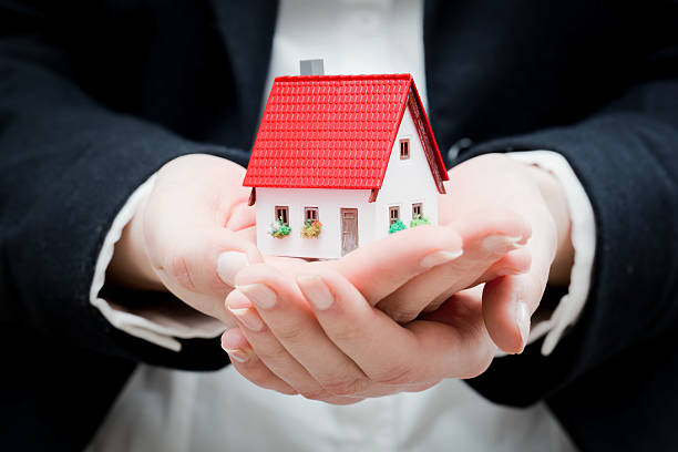 istock Real estate agent holding a small new house 518310753