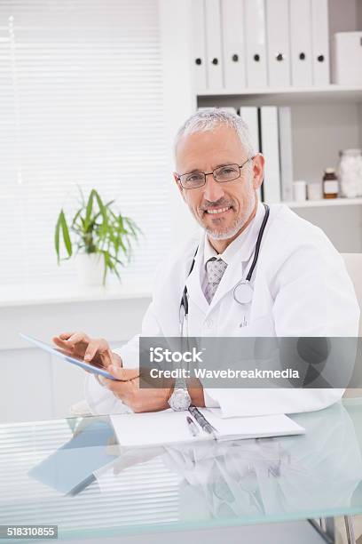 Smiling Doctor Using A Tablet Pc Stock Photo - Download Image Now - 40-49 Years, 45-49 Years, Adult