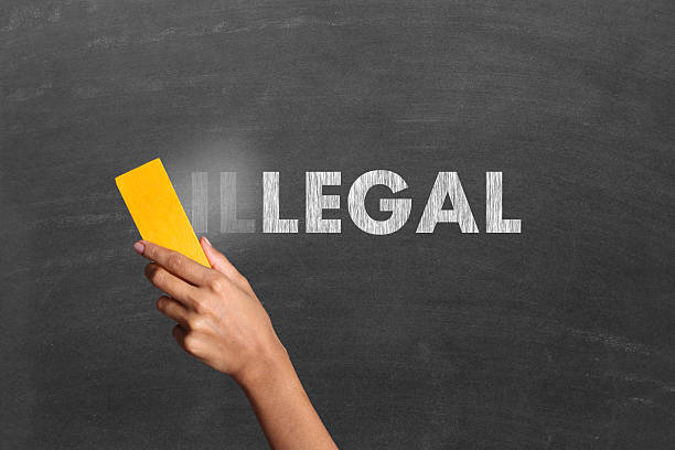 Changing Illegal to legal Changing word Illegal into Usable. Close-up of a person hand holding duster and cleaning blackboard written the word "Illegal". Illegal turned into legal. Concept of usability or accessibility. board eraser stock pictures, royalty-free photos & images
