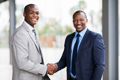 portrait of happy african american businesspeople handshaking