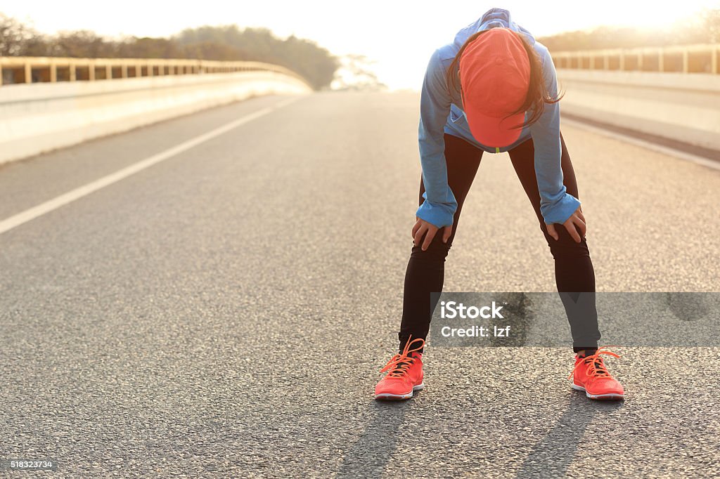 Müde Frau Läufer eine Erholung nach dem Laufen ist anstrengend - Lizenzfrei Rennen - Körperliche Aktivität Stock-Foto