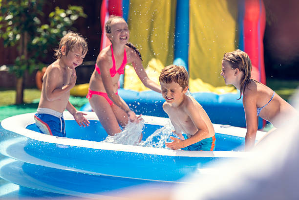 istock Kids playing in an inflatable pool in the back yard 518325740