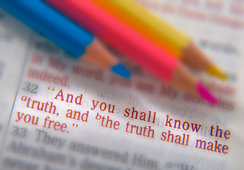 And you shall know the truth, and the truth shall make you free. Bible text from John 8:32, the Bible. Blue, red and yellow crayons. Visual effects to emphasize the message. Macro