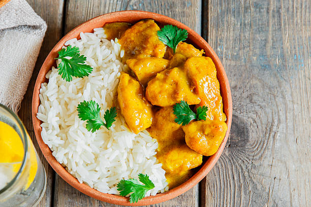 istock chicken curry with rice on a wooden surface 518338344