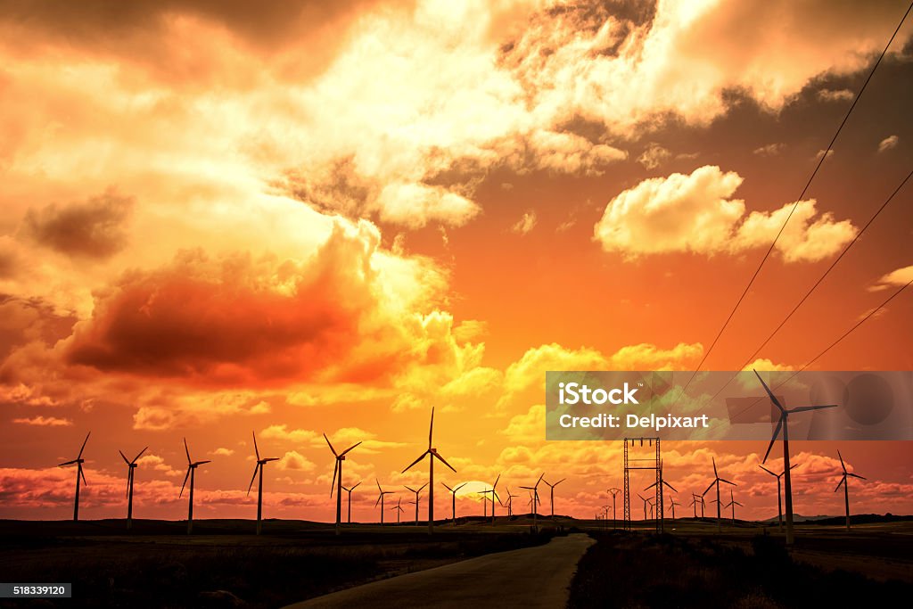 Wind turbine field at sunset, dramatic sky Electricity Stock Photo