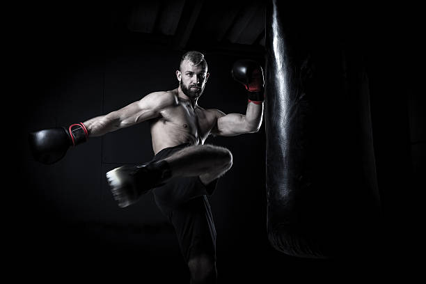 istock Male Athlete boxer punching a punching bag 518339240