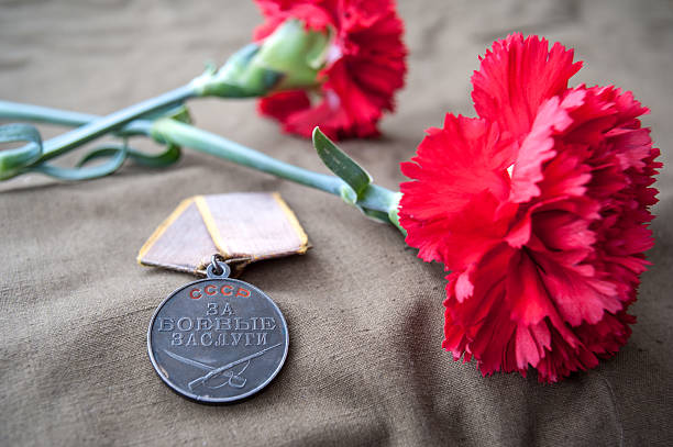 istock Soviet Medal for Combat Service and two red carnations. 518339568