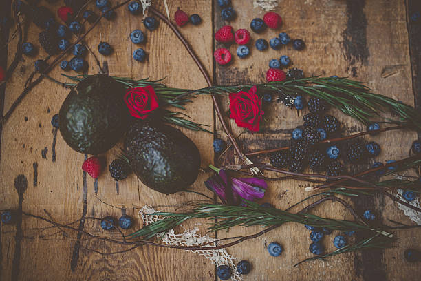 Berries, plums and avocados on barnwood