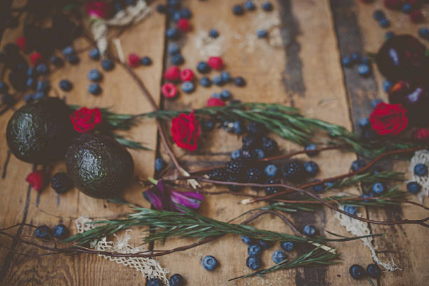 Berries, plums and avocados on barnwood