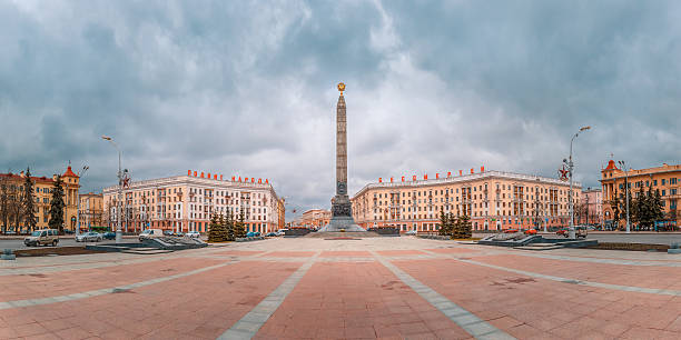 Victory Square in Minsk, Belarus Monument in honor of the victory in World War II at Victory Square in Minsk, Belarus. Panorama. Red letters read Heroic deed of the people is immortal minsk stock pictures, royalty-free photos & images