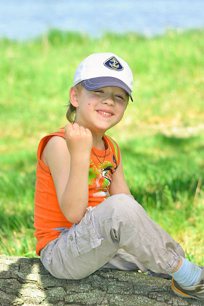 istock boy sitting on a log in nature 518349828