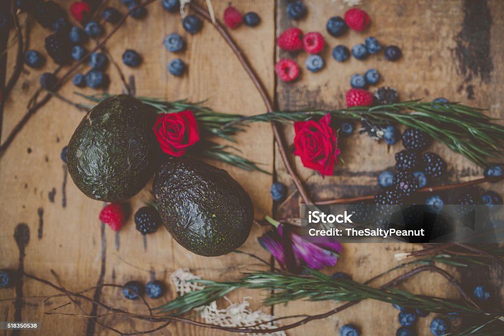 Berries, plums and avocados on barnwood A spring mixture of blackberries, raspberries, blueberries, plums and avocados on a rustic barnwood floor. Avocado Stock Photo