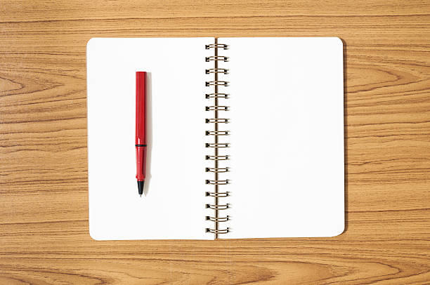 istock notebook with a red pen on wood background 518350924