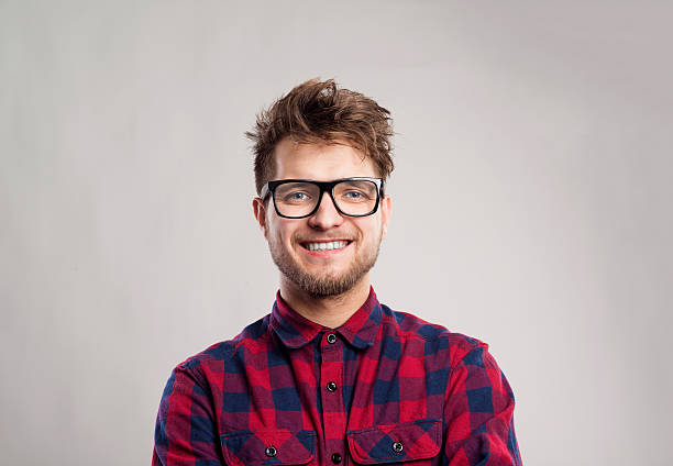 Cheerful funny looking nerdy guy with ginger hair and eyeglasses having beard.