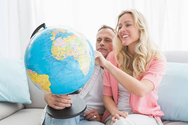 istock Happy couple looking at a globe 518352751