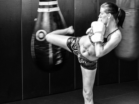 Female kickboxer working-out on bag