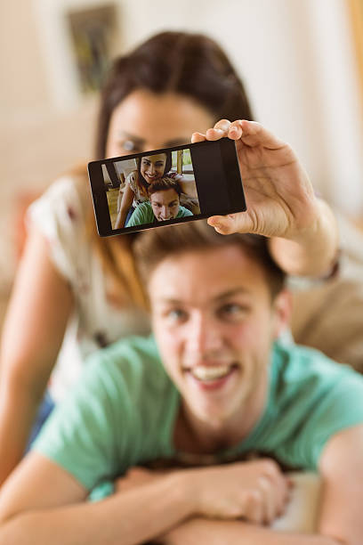 istock Cute couple taking a selfie on couch 518354985
