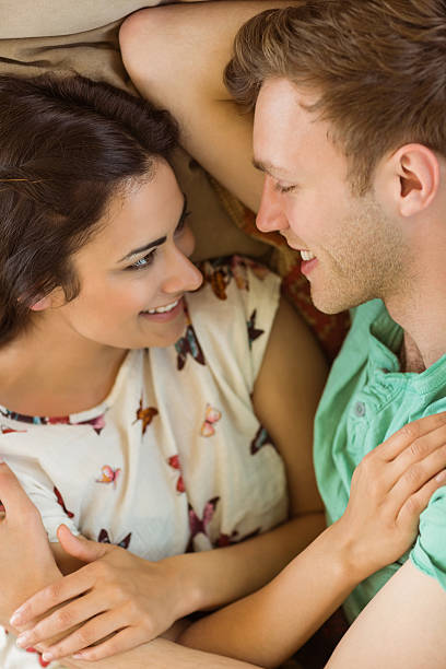 istock Cute couple cuddling on couch 518355091