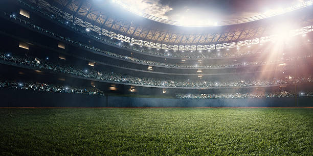 Baseball stadium A wide angle of a outdoor baseball stadium full of spectators under a stormy night sky and rain. The image has depth of field with the focus on the foreground part of the pitch. bleachers stock pictures, royalty-free photos & images